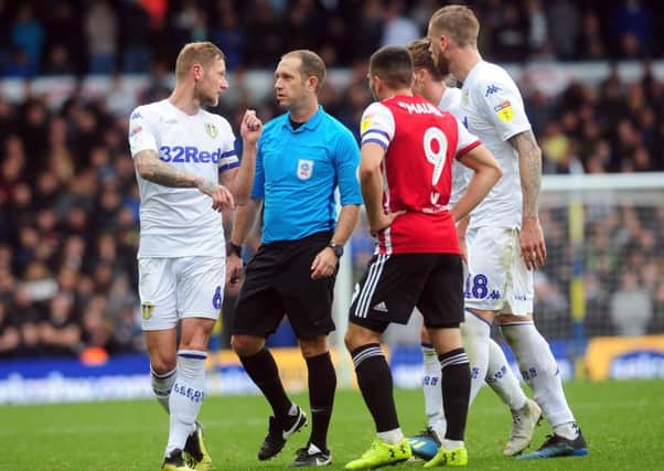 Leeds United captain Liam Cooper speaks to controversial referee Jeremy Simpson during the game with Brentford.