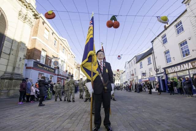 Pontefract Remembrance, Market Square, Pontefract, England - A standard bearer prepares to set off on the Pontefract remembrance parade.