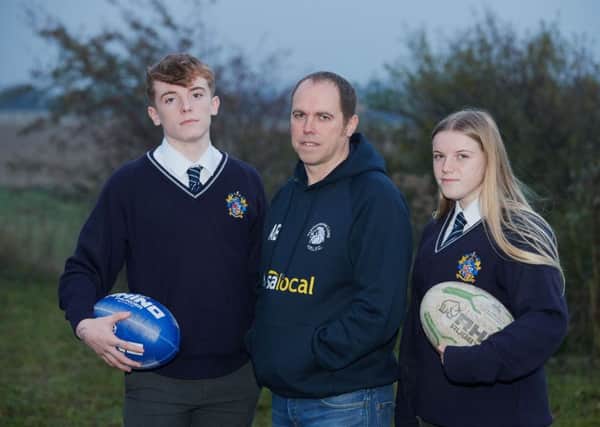 Andrew Bell has set up a petition to bring Rugby League back to Featherstone Academy after the school replaced it with Union. Pictured are Andrew with is two children Elliott and Millie