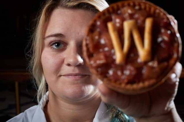 Emily Hofmann holds her new WFD PIE aloft in Wakefield Cathedral as part of Wakefield BIDS WFD 130 campaign to celebrate 130th anniversary of Wakeys city status