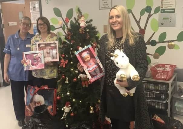 Festive handover: Zoe Gaitley (right) hands over the presents to staff at Pinderfields.