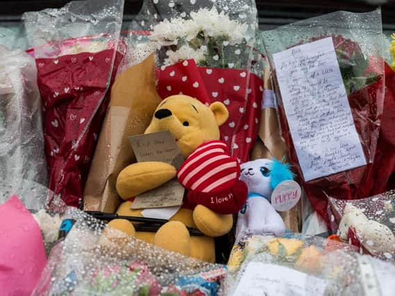 Soft toys and floral tributes placed outside the house on Second Avenue at Rothwell after the fatal fire.