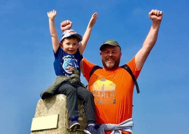 Charlie Batham with his dad, Paul, at the peak of Holyhead Mountain.