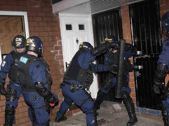 Officers using a battering ram to gain access to a property. (pic by WYP)