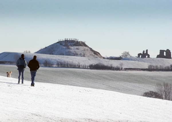 w2862c610 Snow pictures - a dog walker at Pugneys on Saturday morning (Sandal Castle in the background)