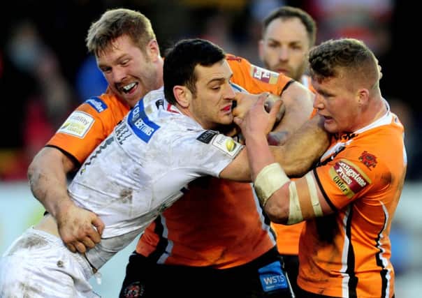 Wakefield Wildcats' Craig Hall is stopped by Castleford Tigers players Ryan Boyle and Adam Milner. Picture: James Hardisty
