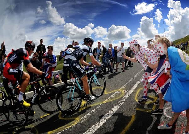 Fans cheer on cyclists as they tackle the Holme Moss climb during the Tour de France in Yoorkshire last summer. Picture by Simon Hulme