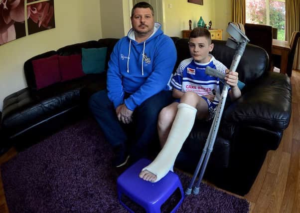 Newspaper: Wakefield Express.
Story: Eleven years old Drew Wright from Normanton, West Yorkshire, was left waiting on a rugby field in agony for almost three hours after a bad tackle left him with a shattered fibia, tibia and ankle. The family were advised to complain by paramedics who arrived on the scene and he is now using crutches.
Drew is pictured with his father, Chris.
Photo Date: 30/04/15
Photo Ref: AB019a0415