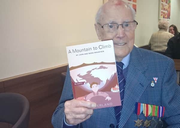 World War Two veteran John Mountain with a book about him escaping from Italy into Switzerland