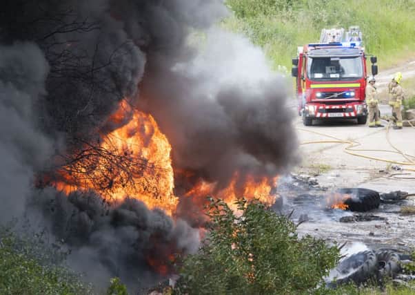 Firefighters tackle a fire in a disused quarry at South Elmsall where old tyres were set alight adjacent to the Dale Lane Industrial area