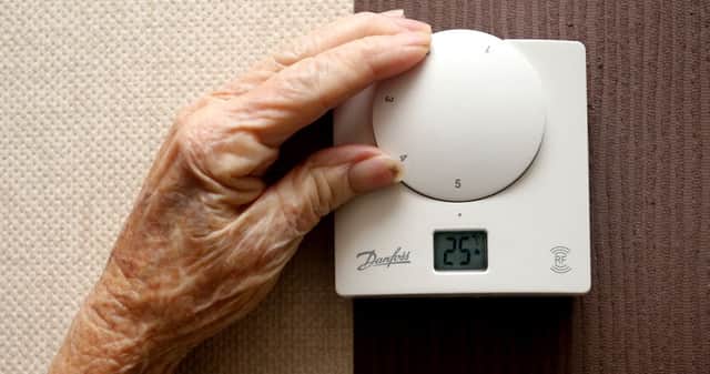 A woman adjusting a thermostat Photo: Peter Byrne/PA Wire