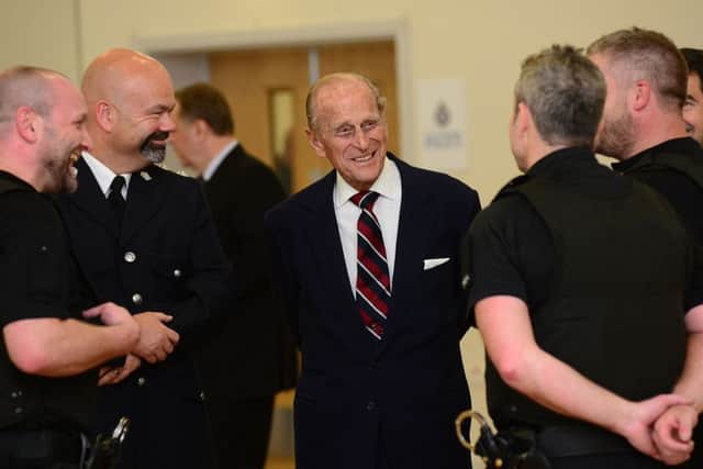 Duke of Edinburgh chats with police officers.