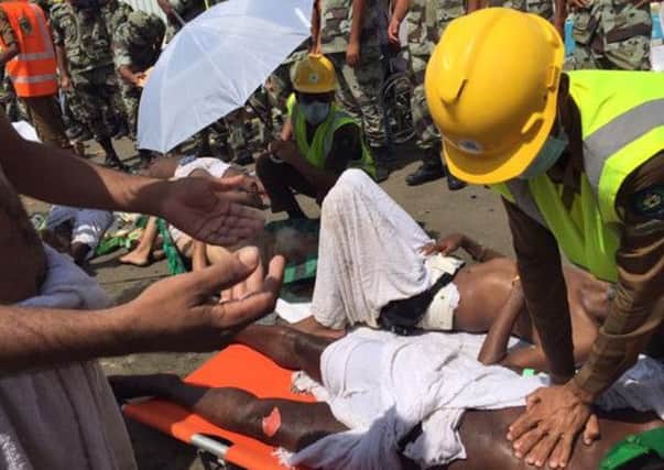 In this image posted on the official Twitter account of the directorate of the Saudi Civil Defense agency, a pilgrim is treated by a medic after a stampede that killed and injured pilgrims in the holy city of Mina.