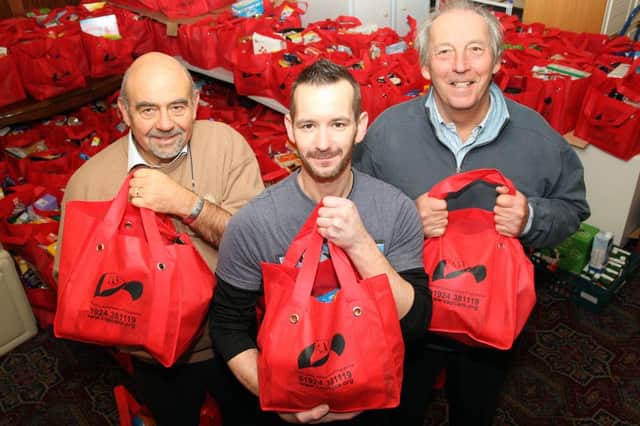 Hampers are being made up at the Community Awareness Programme to provide food aid for poor families this Christmas.Bob Guard (left) and John Waterhouse (right) from Wakefield Chantry rotary club and Tony Cox (centre) from CAP