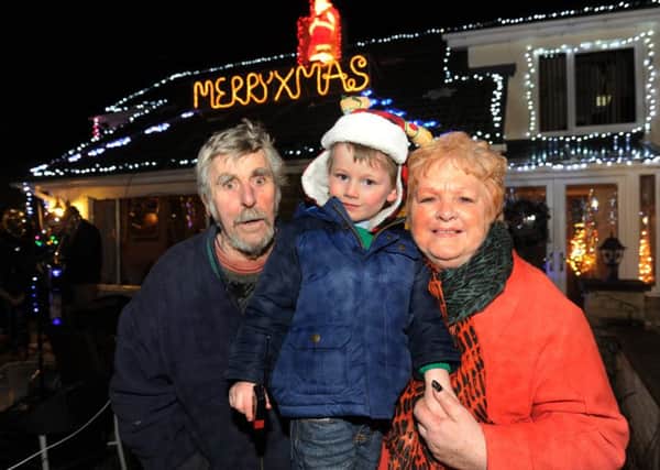 Four year old Aiden Sharpe switches on the Christmas lights at the home of grandpapents Jon and Jennifer Sharpe at their home in Featherstone