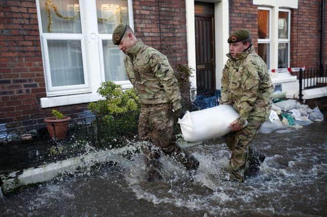 Members of the armed forces help distribute sandbags to residents following flooding in Carlisle.  Owen Humphreys/PA Wire