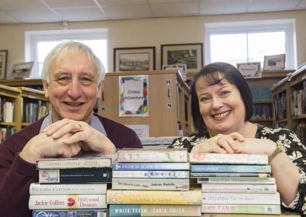 Treasurer Roger Brown and library manager Helen Shaw at Ackworth Community Library with a pile of books.