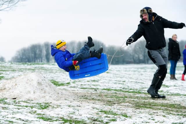 Children playing in the snow at Temple Newsam. Pictured is Ewan Thomas from Cross Gates, who takes off with the help of Adam Dykes.
 (
Picture Jonathan Gawthorpe)
