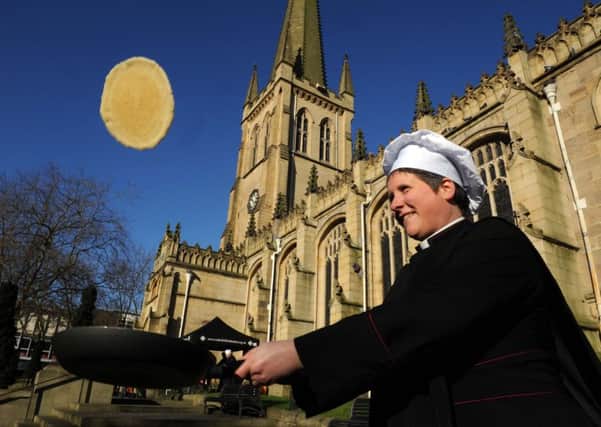 Canon Toni Hofbauer tossing a pancake at Wakefield Cathedral in 2015