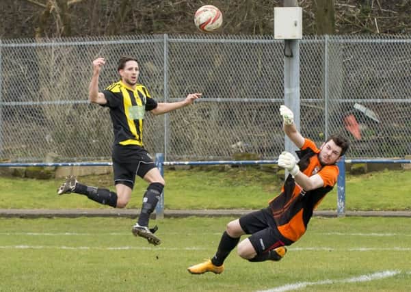 Pontefract Collieries goalkeeper Liam Corberty makes a save to deny Nostell MW's Simon Poole.