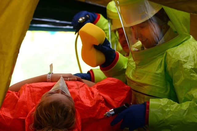 Ambulance crew in 'chemical suits' decontaminate a 'casualty'. Picture Scott Merrylees
