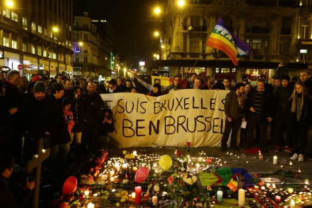 Members of the public gather at the Place de la Bourse in Brussels to leave messages and tributes following the terrorist bomb attacks