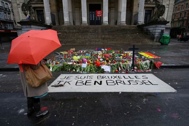A lady stops to view the floral tributes and candles left in the Place de la Bourse, Brussels, following yesterdays terrorist attacks in the city.