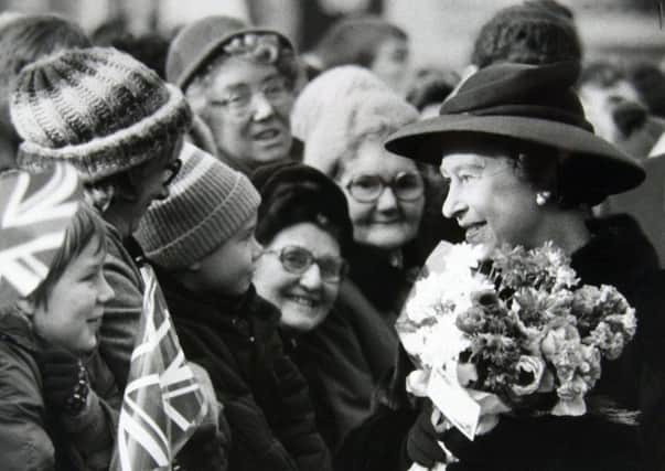 The Queen chats with children in the crowd waiting to greet her in Wakefield on November 25 1982.