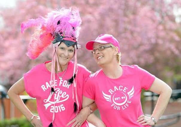 Double cancer survivor Julie Hawkins, left, stands shoulder-to-shoulder with her best friend Lyndsey Garrett.
