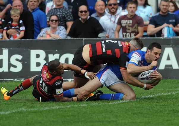 Craig Hall scores a try for Wakefield against Warrington.
