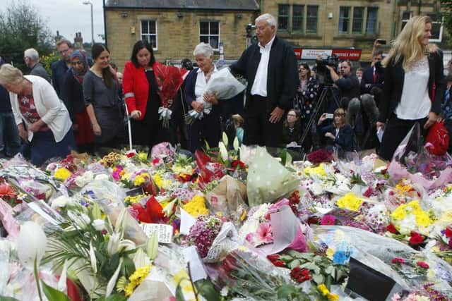 Gordon and Jean Leadbeater (centre), the parents of Labour MP Jo Cox, her sister sister Kim Leadbeater (right) join family members as they look at floral tributes left in Birstall. Credit: Danny Lawson/PA Wire