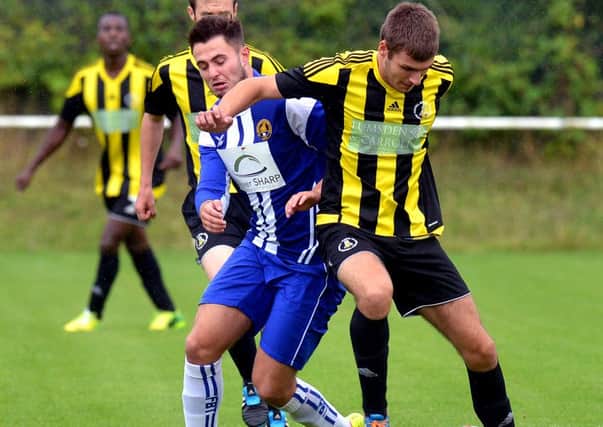 Nostell MW's Alex Stacey and Glasshoughton Welfare's Lewis Akeister battle for the ball.