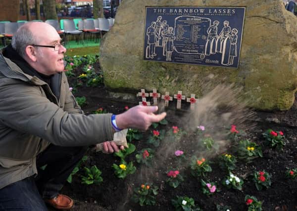 Wayne Levitt scatters soil from the Somme on a tribute.