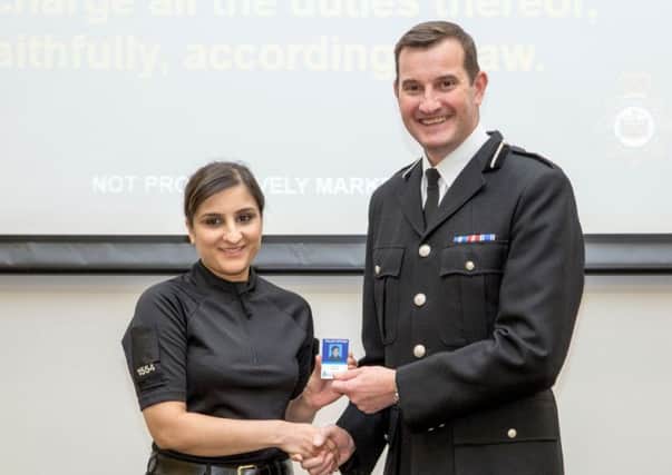 PC Amna Naseer receives her warrant card from Temporary Deputy Chief Constable John Robins. 
Picture: Tom Walton
