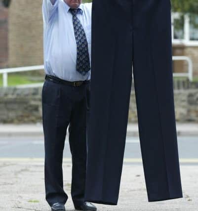 Tributes: The family of Walter Grimes, pictured with trousers made for the Worlds tallest man Xi Chun  have paid tribute after he passed away.