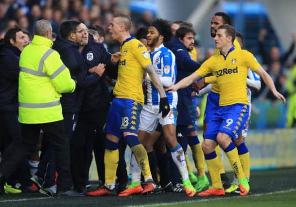 Tempers flare on the touchline as Huddersfield Town manager David Wagner (left) and Leeds United's Pontus Jansson (centre) confront each other. Picture: Nigel French/PA