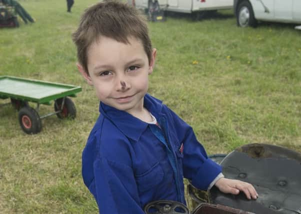 Harvey Gough (5) shovels coal into one of his family's small engines.