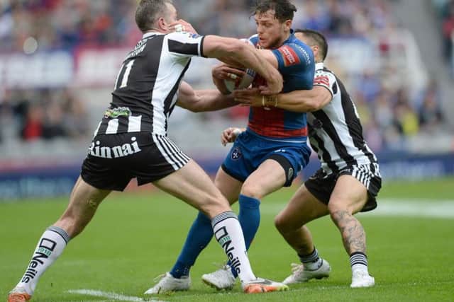 Wakefield Trinity's Scott Grix is tackled by Widnes Vikings' Chris Houston and Rangi Chase (right) (Photo: PA)
