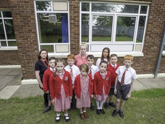Pupils and staff in front of the smashed windows at St Joseph's Primary School.