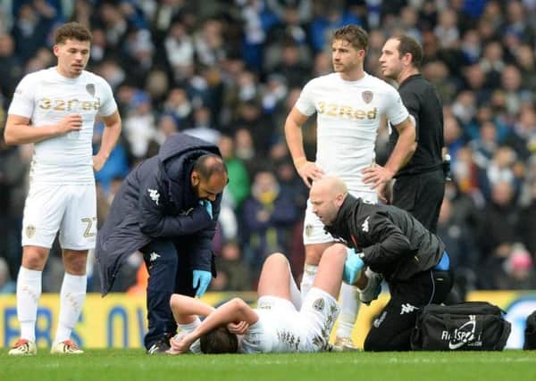 Injured Luke Ayling receives treatment on the field during Leeds United's game with Nottingham Forest and is now out for the season.