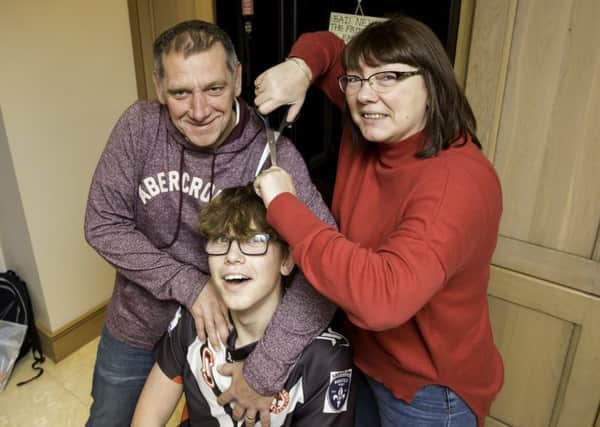 Lewis Costello preparing for his head shave with dad David and mum Joanne.
