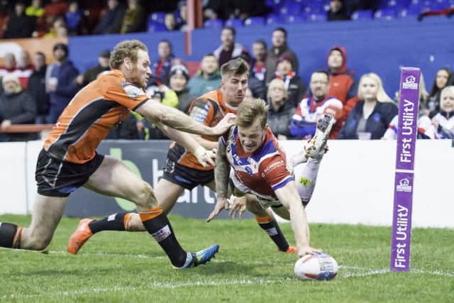 Castleford's Joel Monaghan and Greg Minikin are unable to force Wakefield's Tom Johnstone into touch as he scores a flying try.