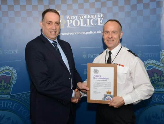 Fire investigator Gary Kendrew is presented with his commendation by Det Chief Supt Mark Ridley, of West Yorkshire Police.