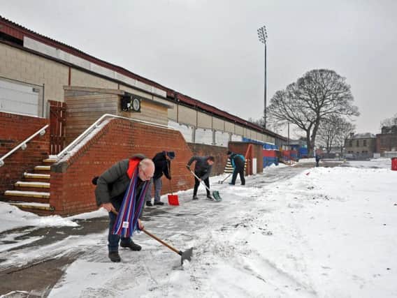 Fans help clear the pitch for Wakefield Trinity. Picture: Tony Johnson.