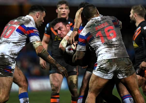 Castleford Tigers' Grant Millington is wrapped up by Wakefield Trinity's defence. Picture:  Jonathan Gawthorpe