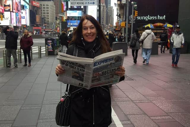 Pauline Newton in Times Square with the paper.