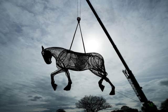 The war horse is lowered into place.